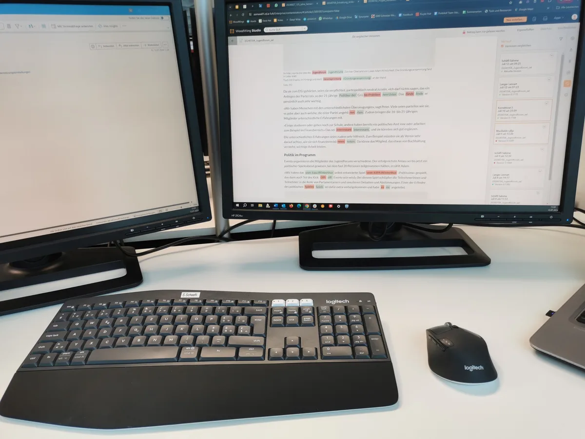 Zwei Bildschirme, eine Tastatur und eine Maus. Auf dem rechten Bildschirm hat es einen Text, bei dem Dinge korrigiert wurden.